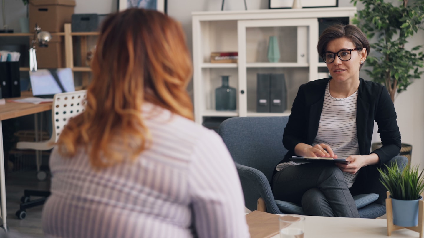 Zwei Frauen in einem professionellen Beratungsgespräch in einem hellen Büro.